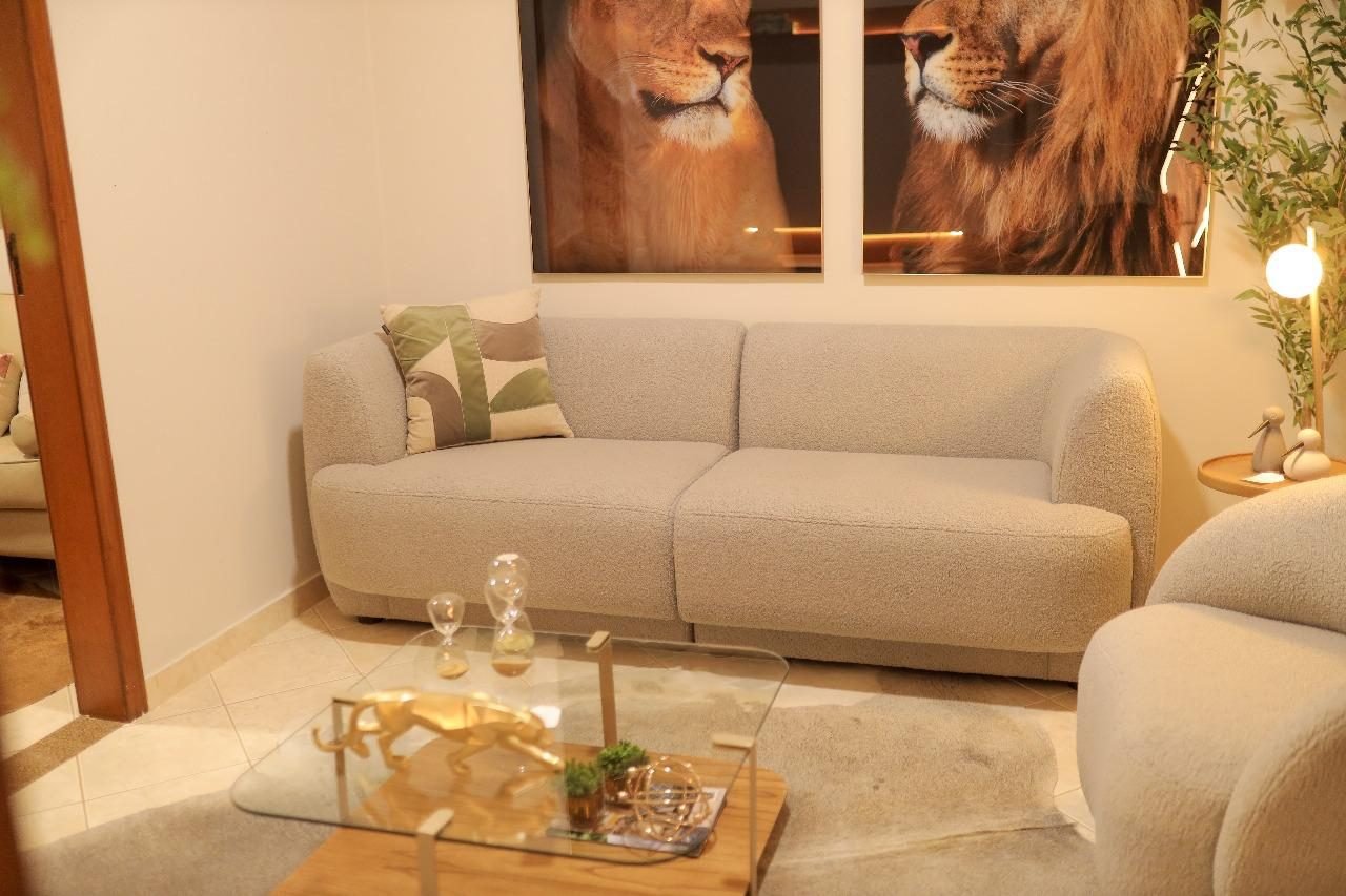 Sala de estar com sofá curvo em tecido claro